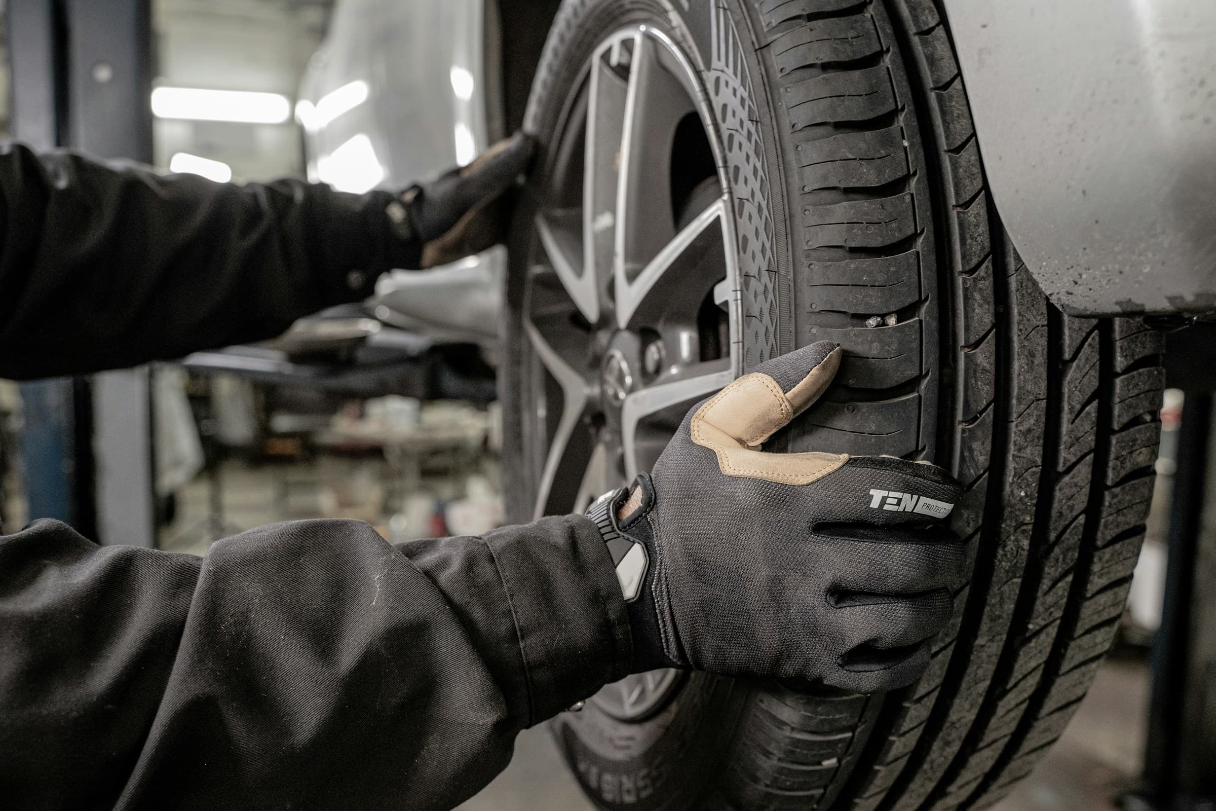 Mechaniker beim Reifencheck in der Werkstatt
